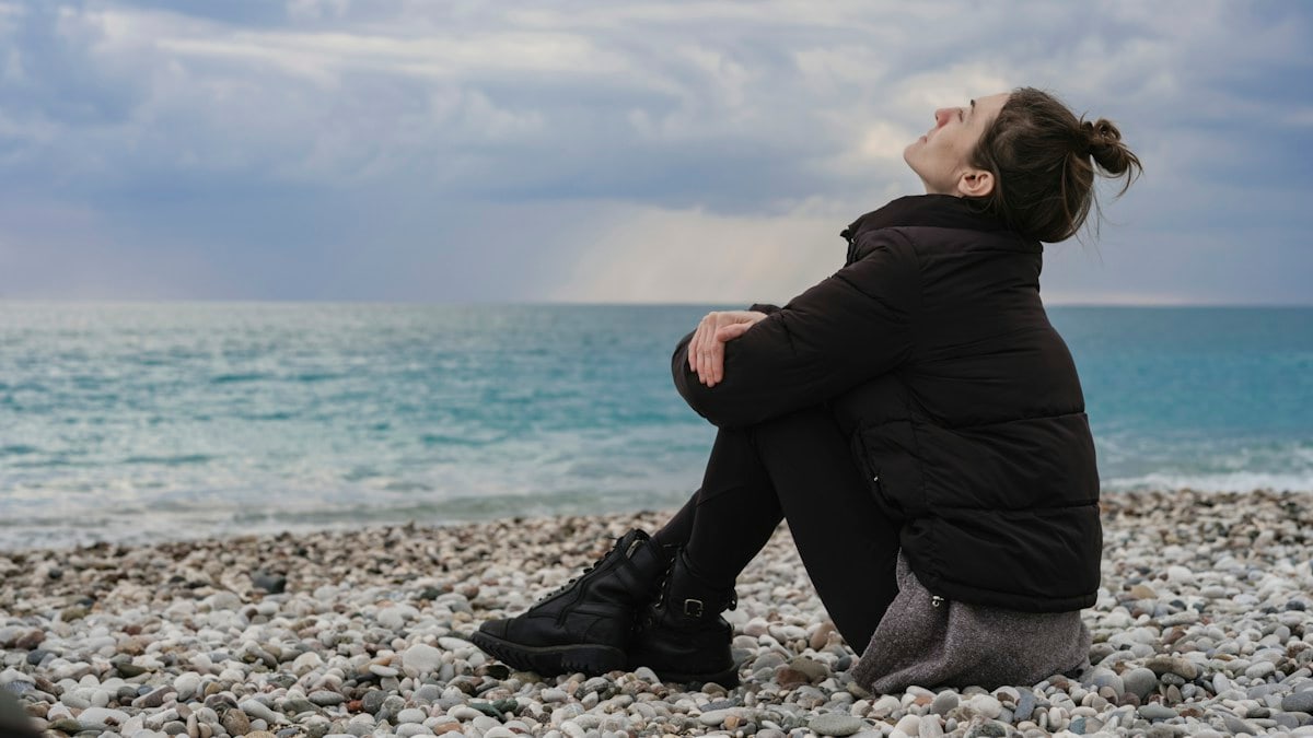 portrait of a woman sitting peacefully on the beach